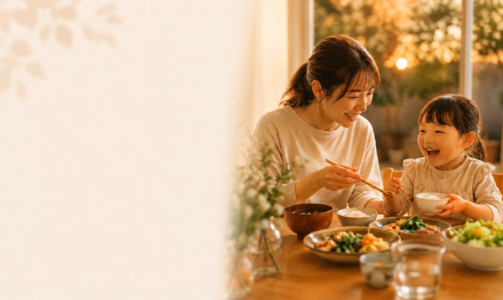 夕暮れの食卓で、母親と子どもが笑顔で食事を楽しむ様子